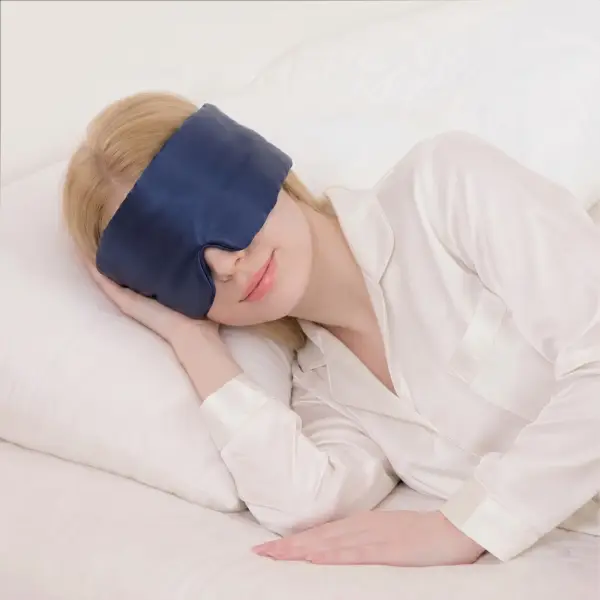 Donna che dorme con una maschera per dormire in seta di gelso