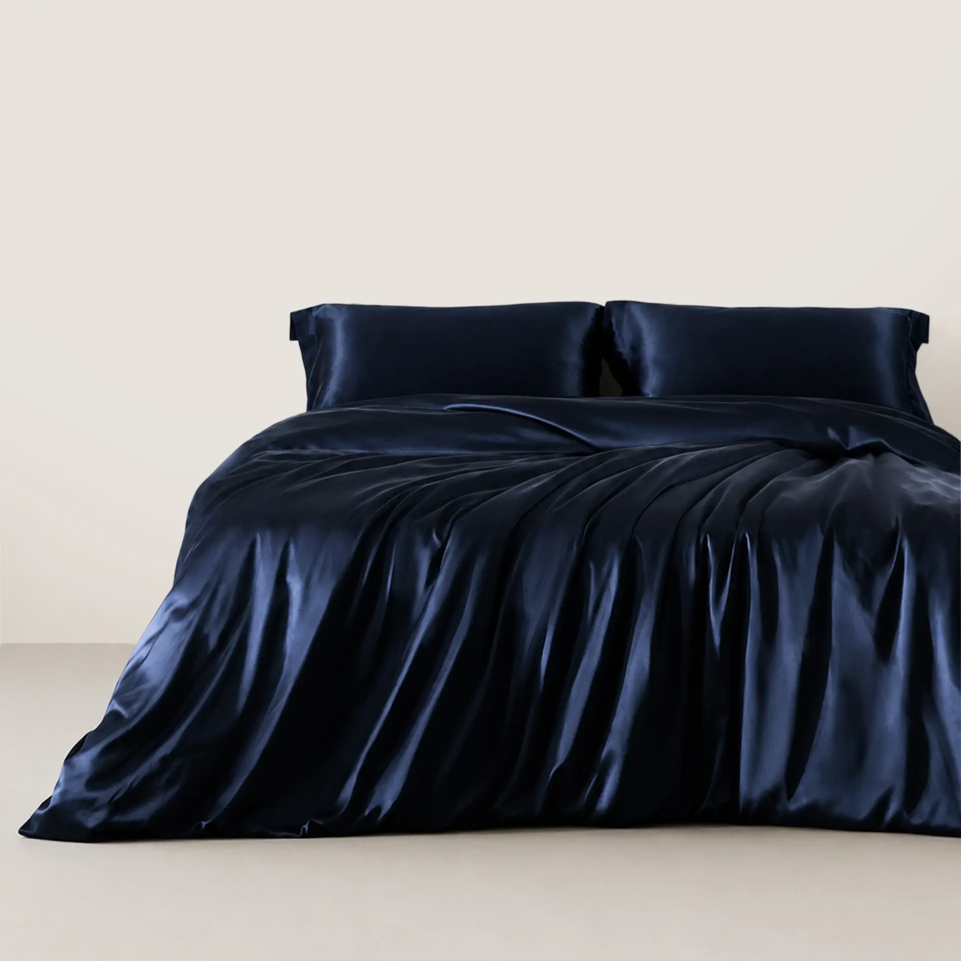 Donker marineblauwe zijden kussenslopen op een bed