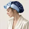 Donna che indossa una cuffia da notte in seta di gelso bicolore blu navy e azzurra con fiocco