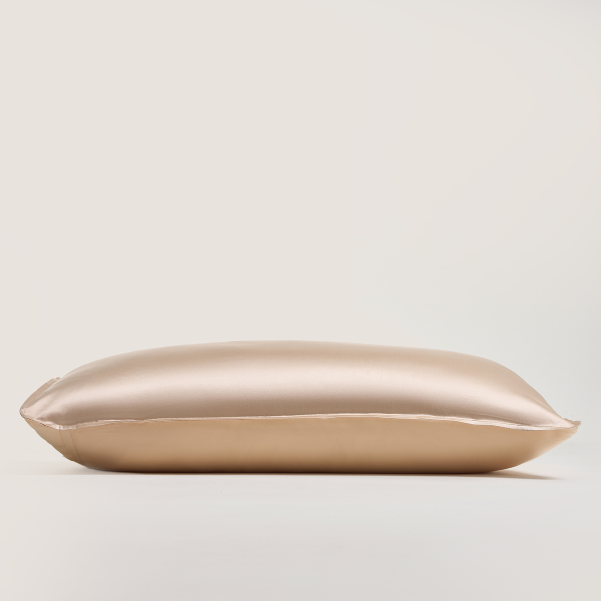 Federa di seta color champagne delicatamente adagiata sul letto