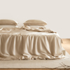 linge de lit en soie de mûrier champagne disposé sur un lit