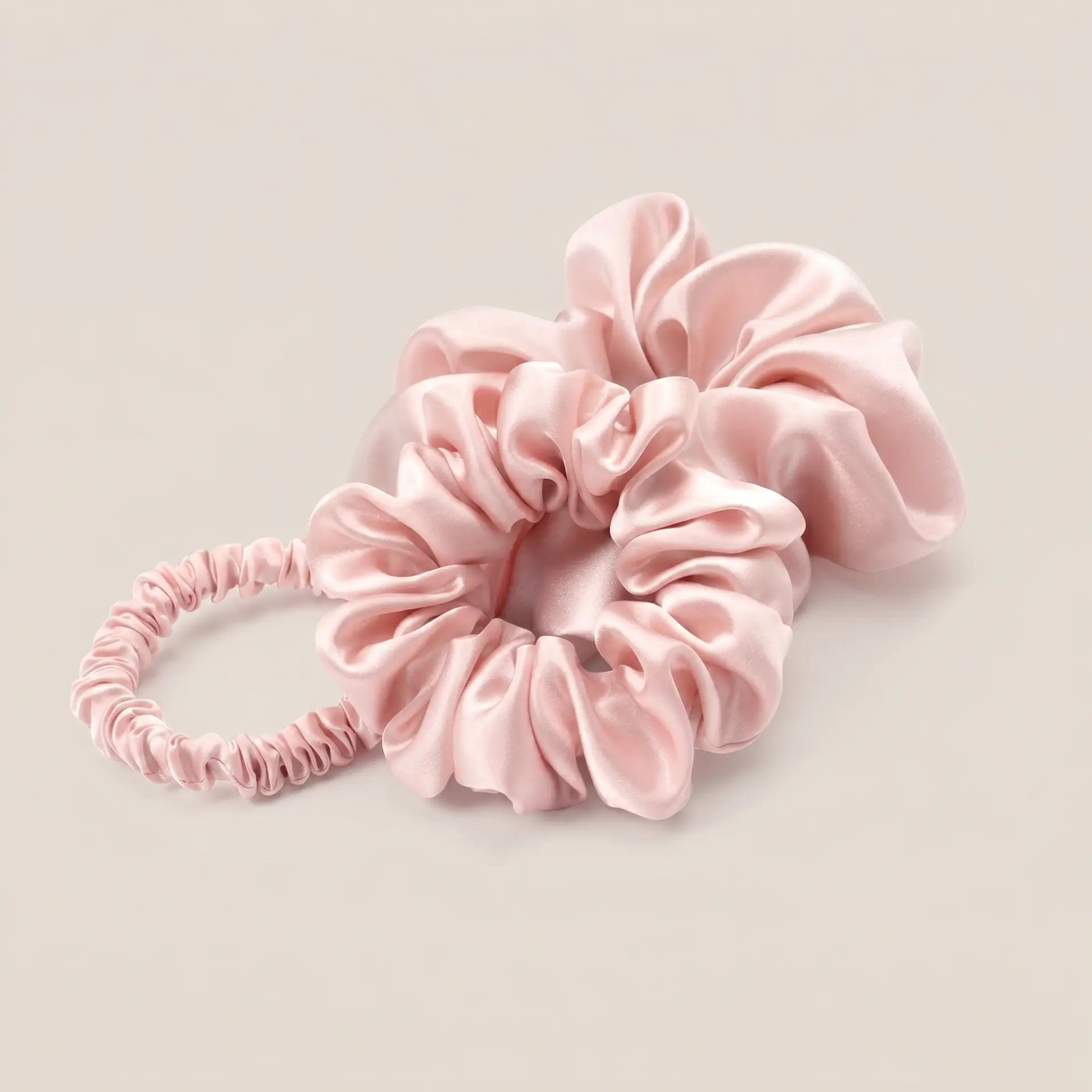 Set roze scrunchies van moerbeizijde in de maten groot, middel en klein