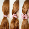 Roze zijden scrunchies in drie maten in lang haar, naast elkaar vergeleken