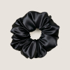 Zwarte moerbeizijden scrunchie om mee te slapen, op een effen achtergrond.