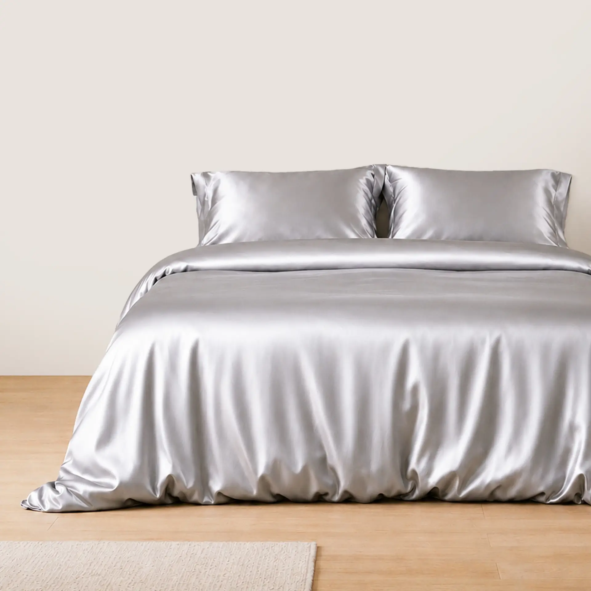 Zilverkleurige zijden kussenslopen op een bed