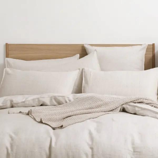 Juego de cama de lino natural, decorado con almohadas superpuestas