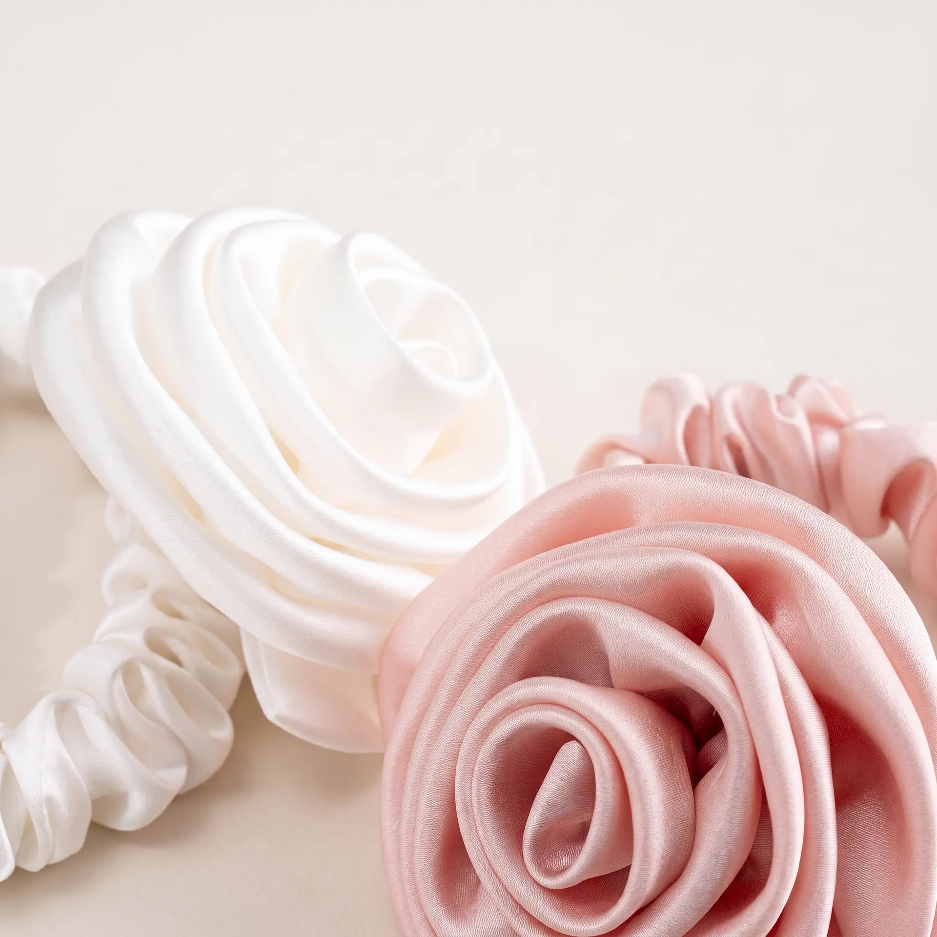 Handgerolde roos van moerbeizijde op de Sensoire Rose Bloom scrunchie