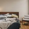 Fundas de cojín Sensoire de lino francés en oliva y natural sobre una cama de lino carbón