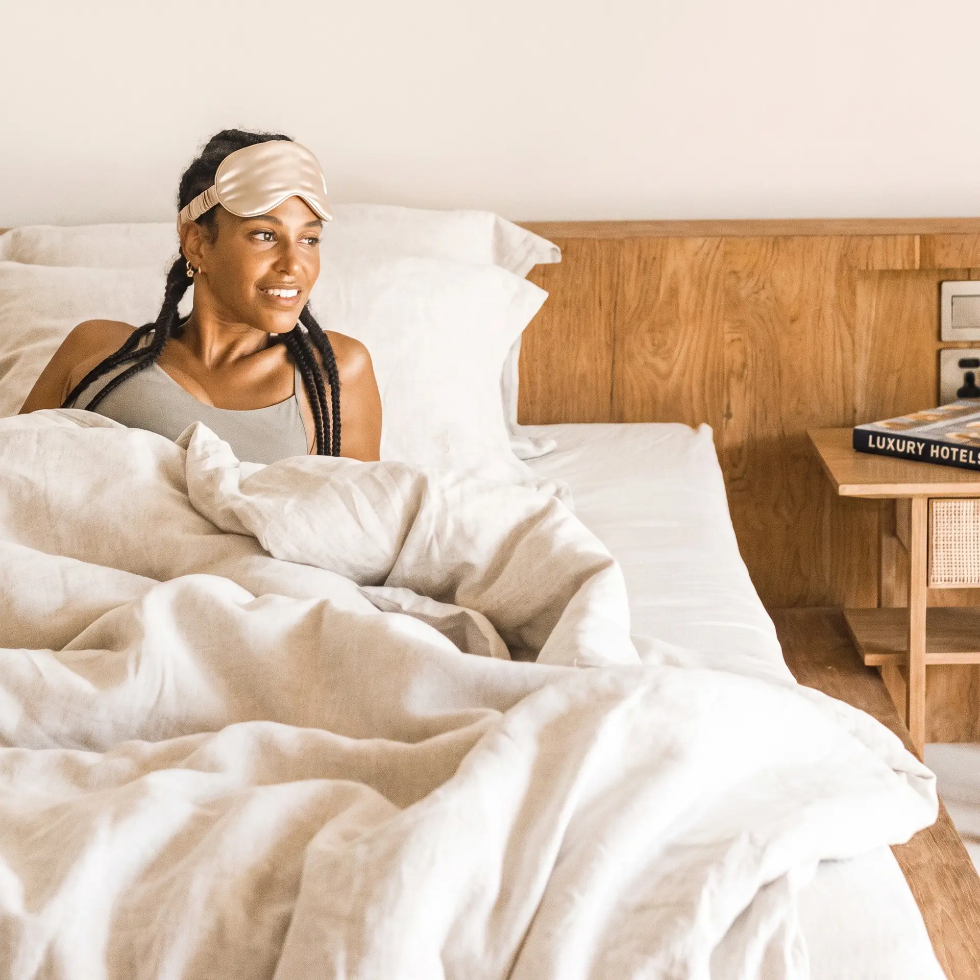 Ropa de cama de lino natural sobre una cama con luz suave de mañana
