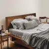 Graues Leinen-Spannbettlaken und Bettwäsche auf einem Walnussbett