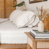 Spannbettlaken und Kissenbezüge aus Naturleinen in einem hellen Schlafzimmer im Boho-Stil