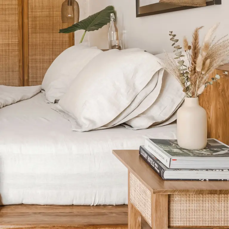 Spannbettlaken und Kissenbezüge aus Naturleinen in einem hellen Schlafzimmer im Boho-Stil