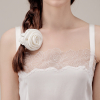 Vrouw met een witte scrunchie van moerbeizijde met rozendetail in een zijvlecht.