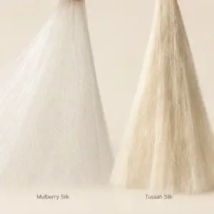 Fins filaments blancs de soie de mûrier à côté de filaments de soie tussah plus épais et plus crème