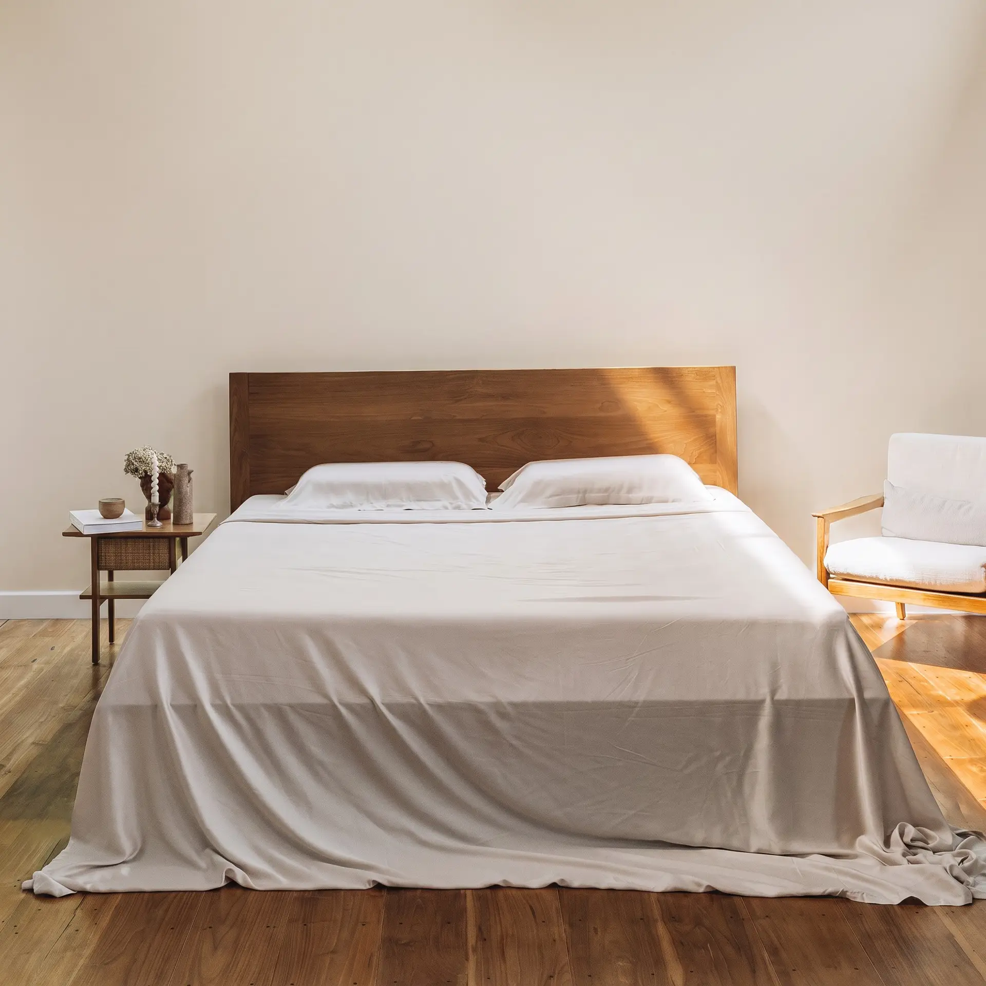 Graues Bettlaken aus Bambus-Lyocell auf einem Bett in sanftem Tageslicht, neutrales Schlafzimmer