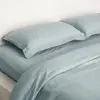 Bettbezug aus taubenblauem gewaschenem Leinen in einem ruhigen Schlafzimmer