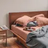 Kissenbezüge aus Bambus-Lyocell in verschiedenen Farben sind auf einem ordentlich gemachten Bett arrangiert.