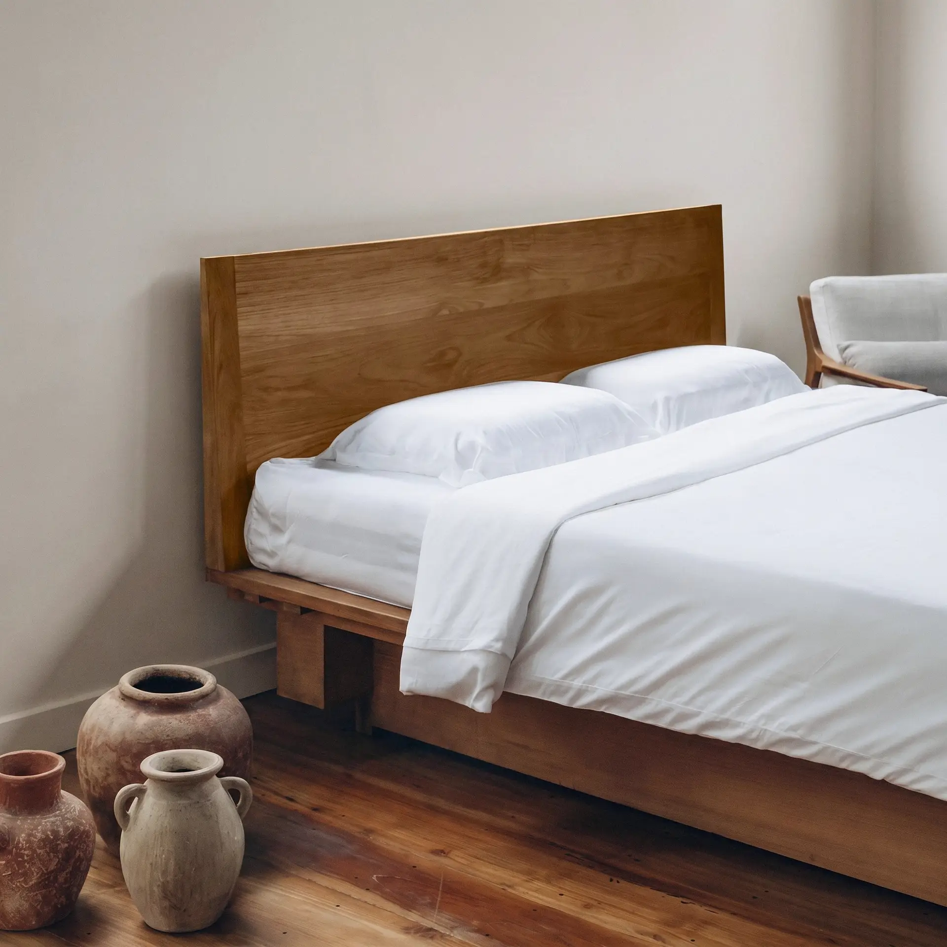 Weiße Kissenbezüge aus Bambus-Lyocell auf einem ordentlich gemachten Bett in einem ruhigen, neutralen Schlafzimmer