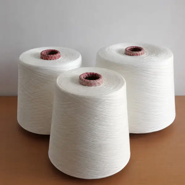 Drie witte garenklossen op een houten ondergrond in een textielatelier.