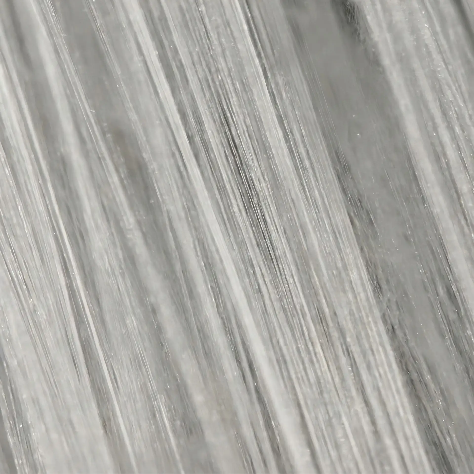 Vue macro de filaments parallèles de soie de mûrier révélant leur éclat naturel