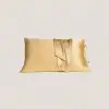 Gouden kussensloop van moerbeizijde met striksluiting, waarbij de flap openvalt om de binnenste strikjes te laten zien.