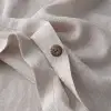 Nahaufnahme eines Kokosnussknopfs an einem Bettbezug aus Hanf in Natur
