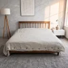 Bettbezug aus Hanf in Natur mit Kokosnussknöpfen auf einem Holzbett