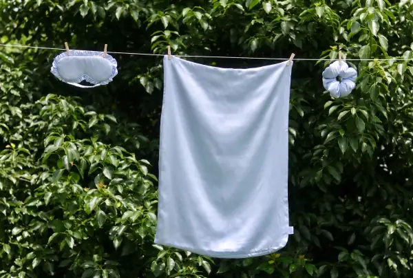 Slaapmasker, kussensloop en scrunchie van zijde aan een waslijn