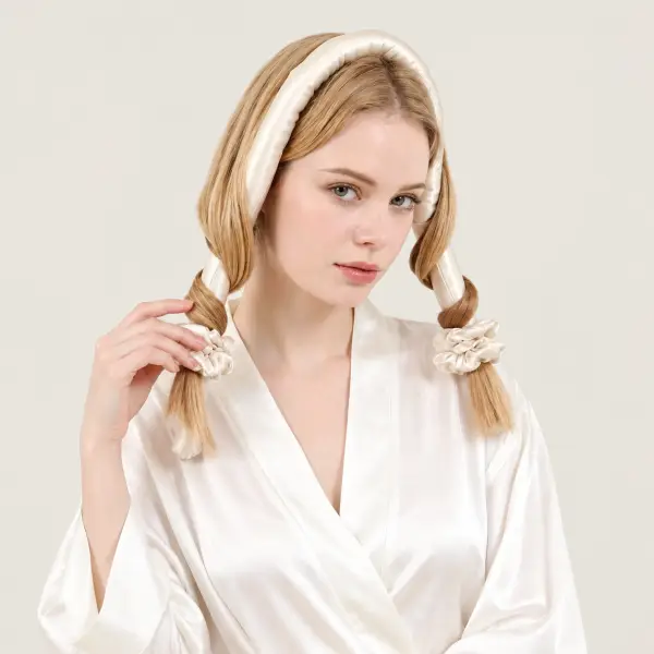 Vrouw met het haar om een ivoorkleurige zijden heatless curler gewikkeld, de uiteinden vastgezet met scrunchies