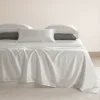 Parure de lit en soie de mûrier ivoire sur un lit fait