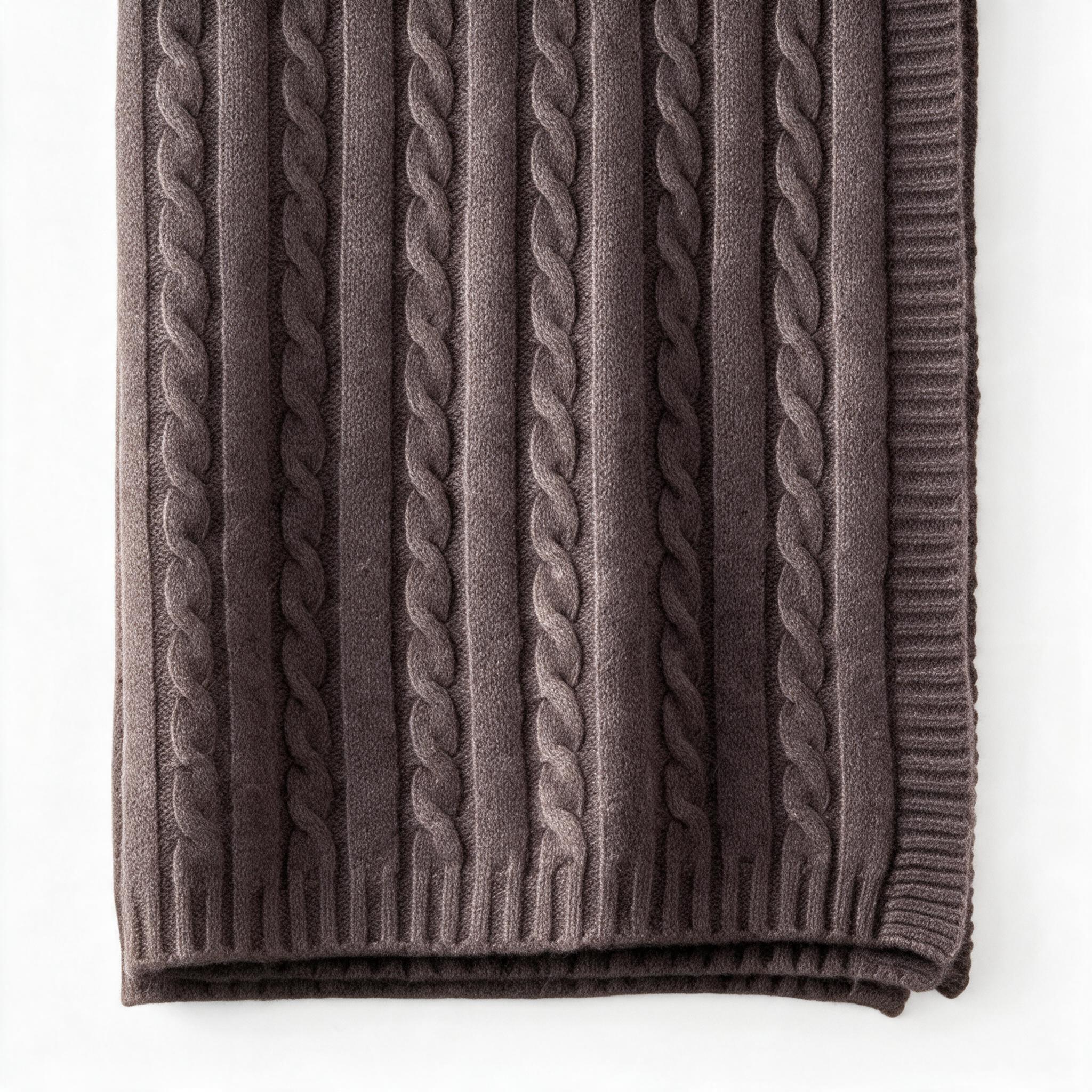 Folded chocolate brown cashmere throw with a ribbed edge and cable knit