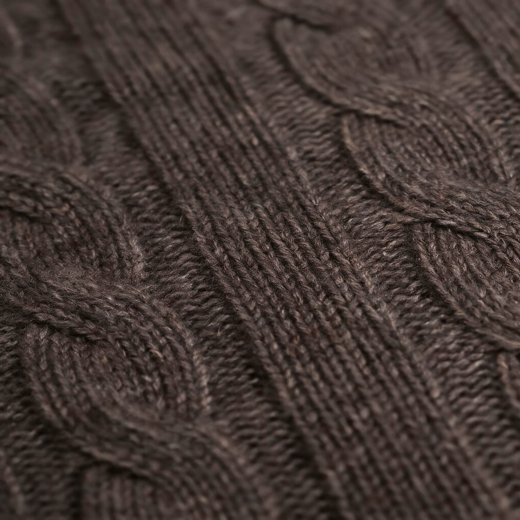 Close up of the cable knit pattern on a chocolate brown cashmere throw