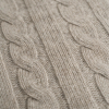 Primer plano del punto de ochos de una manta de cashmere avena