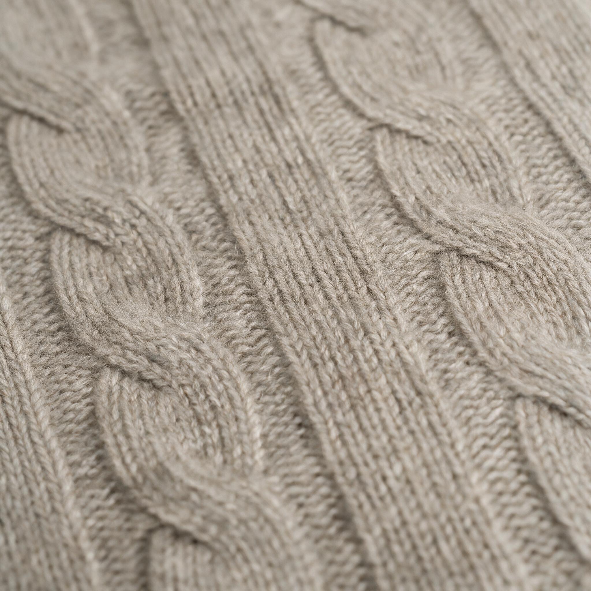 Primer plano del punto de ochos de una manta de cashmere avena