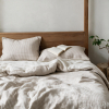Ungemachtes Bett mit Hahnentritt-Bettwäsche aus Naturleinen, Bettbezug zur beigen Seite umgeschlagen
