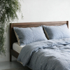 Hahnentritt-Bettwäsche aus Leinen in Blau mit Rückseite aus Naturleinen auf einem Nussbaumbett