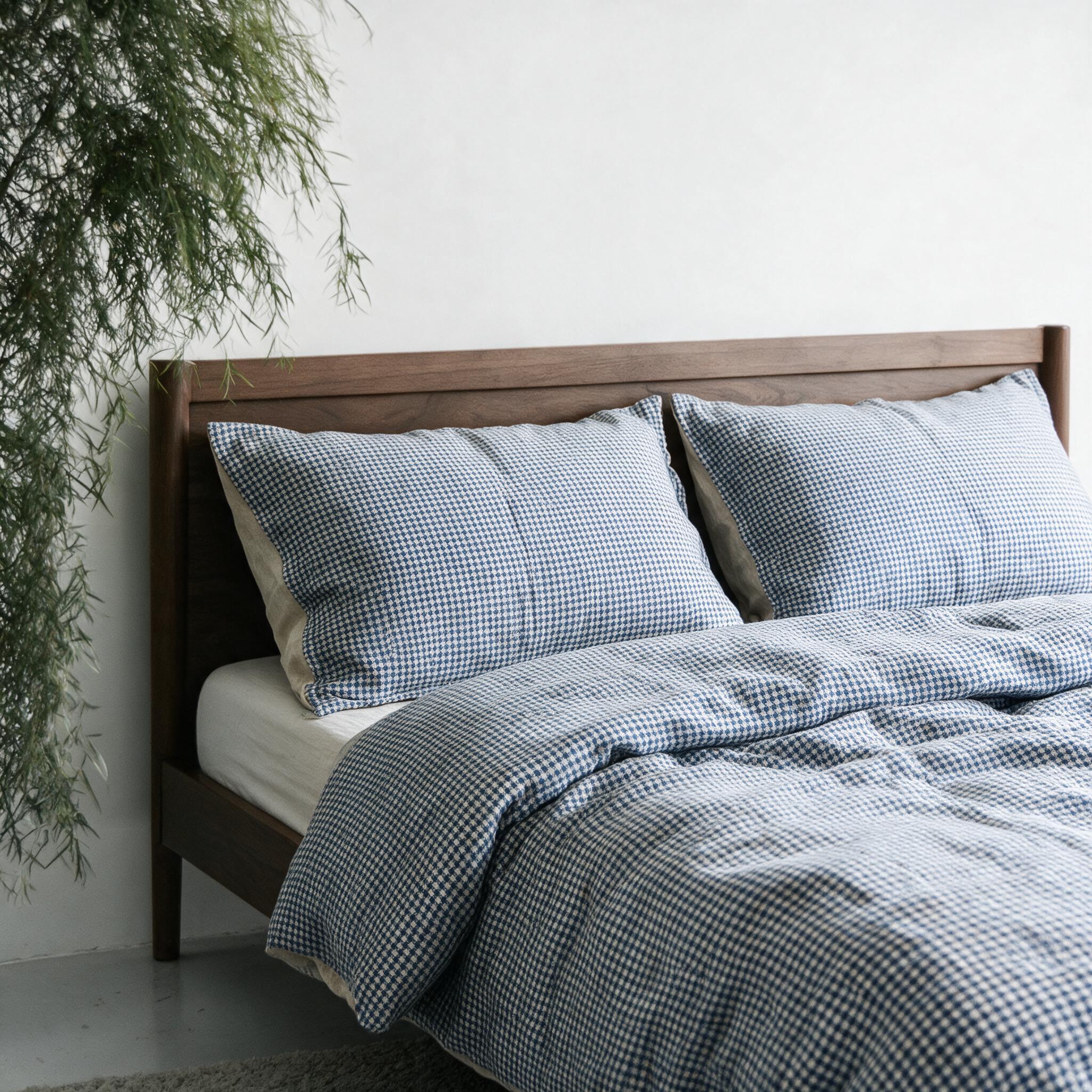 Hahnentritt-Bettwäsche aus Leinen in Blau mit Rückseite aus Naturleinen auf einem Nussbaumbett