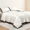 Komplett bezogenes Bett mit dem Noir Contour Bettbezug aus weißer Seide und passenden schwarz eingefassten Kissenbezügen
