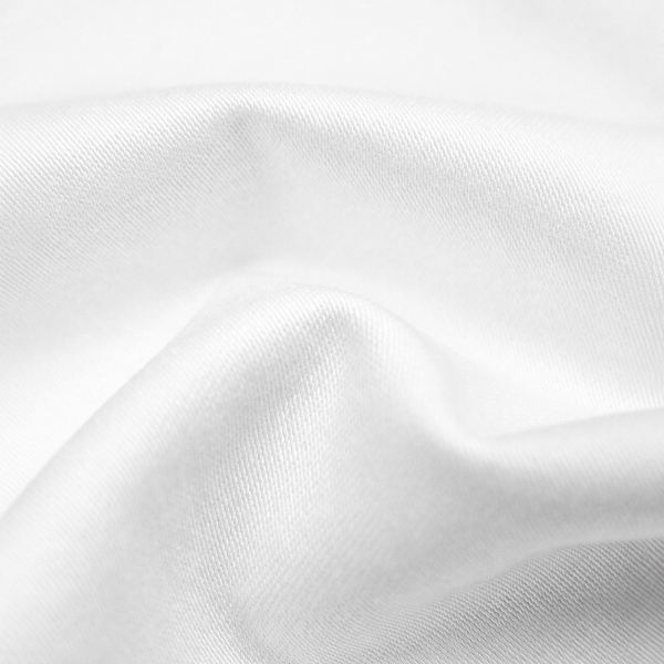 Tejido blanco y suave en pliegues sueltos, con un brillo discreto y uniforme