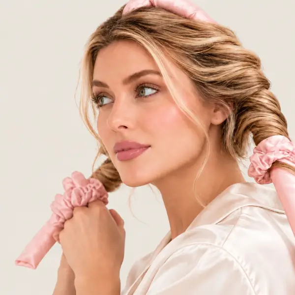 Haar gewikkeld om een roze zijden heatless curler, aan het uiteinde vastgezet met een zijden scrunchie