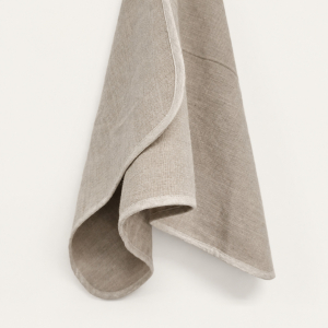 Sensoire natural linen hand towel with an ivory bound edge, hanging in a loose curl