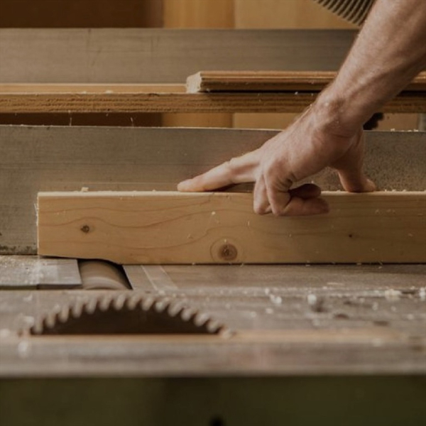 Een lichte houten plank die op een tafelzaag wordt gezaagd