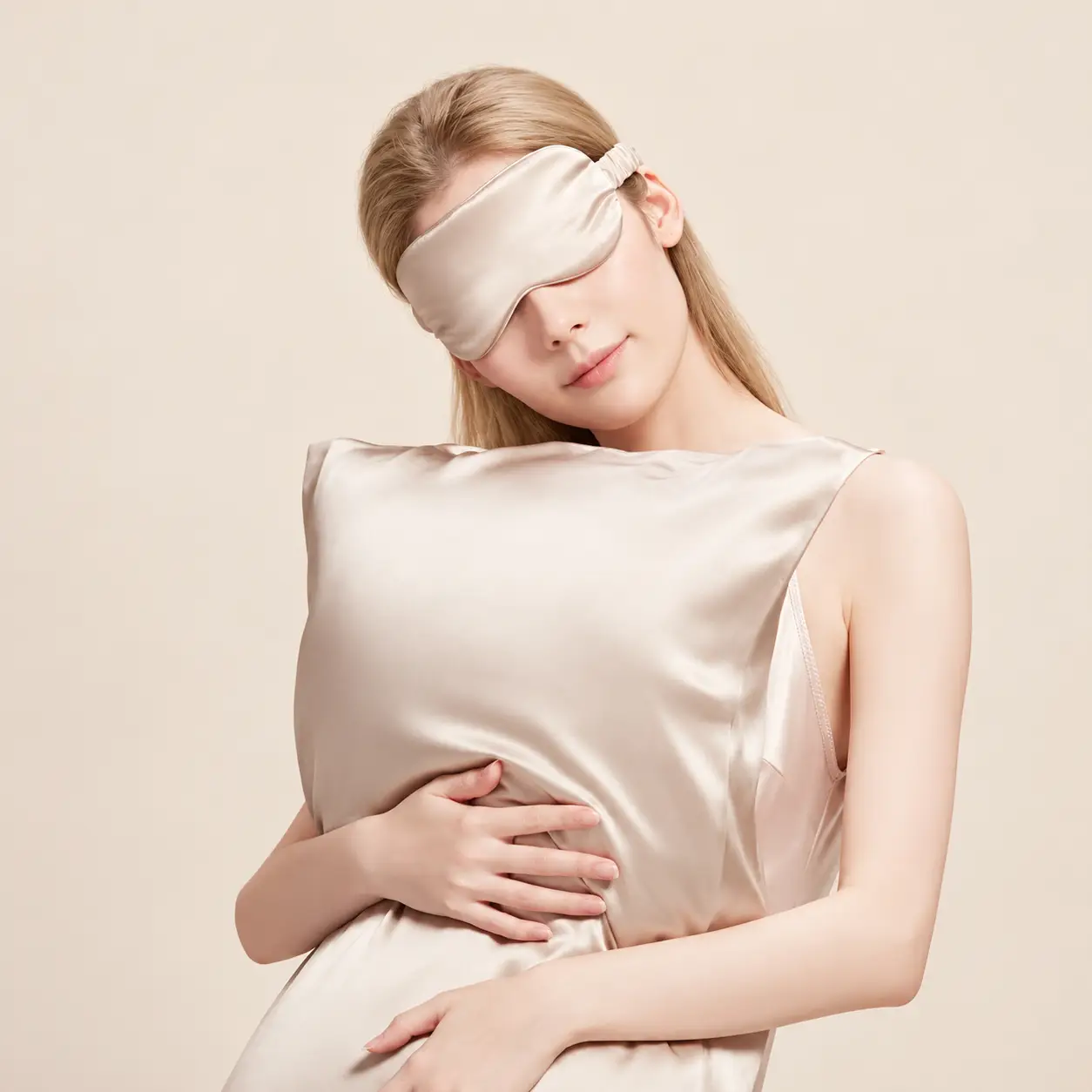 Woman in a champagne silk sleep mask holding a mulberry silk pillow